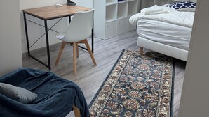 Una camera compatta con un lucernario, un letto, una scrivania con sedia e una libreria.
