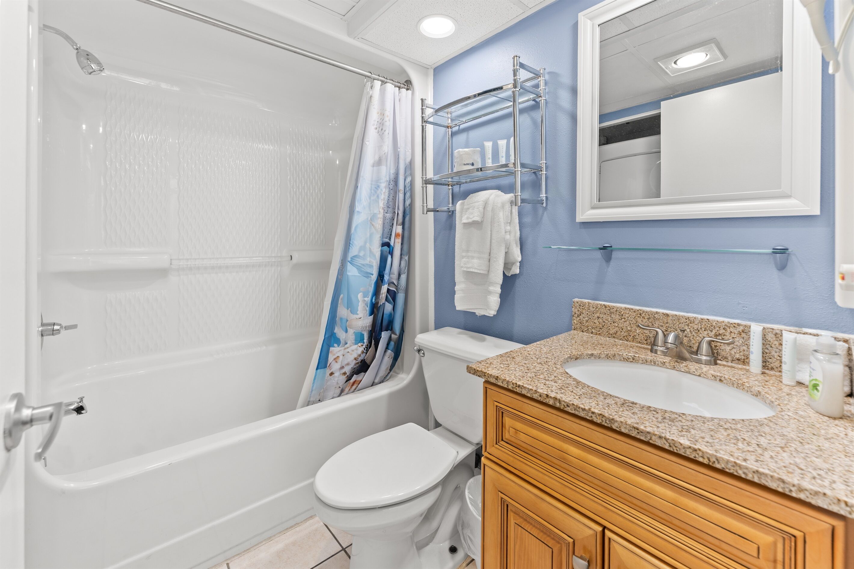 Une salle de bain avec une baignoire, des toilettes, un lavabo et un miroir.