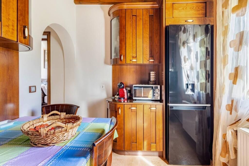 Una cocina compacta con muebles de madera, un microondas y un refrigerador.