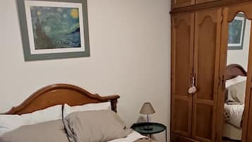Tabla de planchar con plancha y ropa de cama