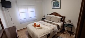Tabla de planchar con plancha y ropa de cama 