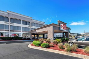 Un hotel Best Western Plus con entrada cubierta, estacionamiento y un edificio con grandes ventanales al fondo.