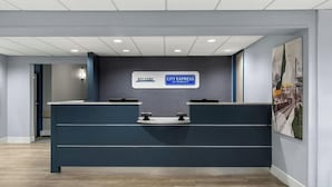 A reception desk with a 'Welcome City Express by Marriott' sign, a counter, and a framed picture on the wall. - Lower South End (Charlotte)