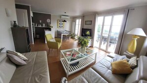 Un salon moderne avec un canapé, une table basse et un coin repas avec des chaises.