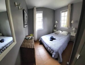 A bedroom with a bed, bedside tables, a mirror, and a window. - Sea-view apartment with large terrace and pool in the heart of the Esterel region (Saint-Raphaël)