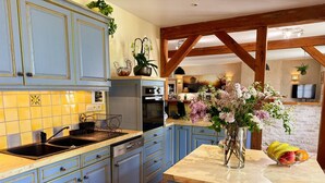 A kitchen with blue cabinets, a marble countertop, and a vase with flowers. - Charming retreat, pets welcome - 8 guests (La Chapelle-Saint-Martin-en-Plaine)