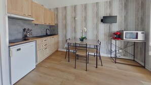 Uma cozinha moderna com armários de madeira, micro-ondas embutido e uma mesa de jantar com cadeiras.