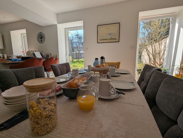 A breakfast setup with a table, chairs, and a view of the outdoors.