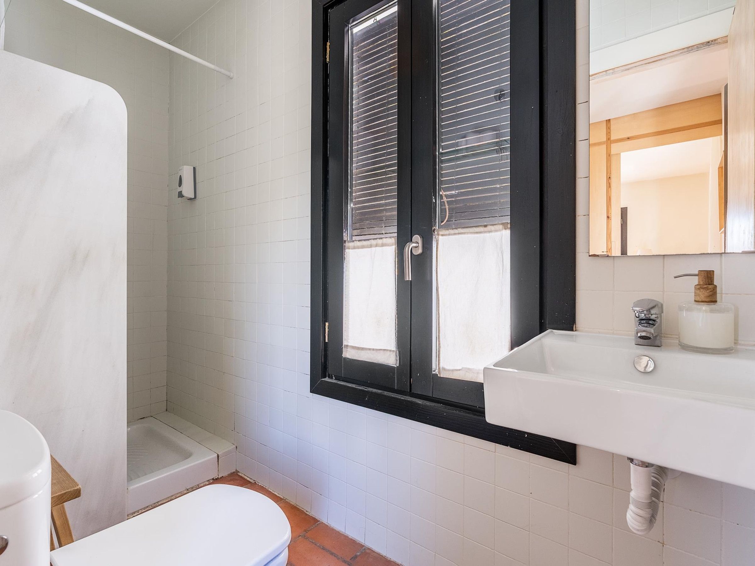 Ein Badezimmer mit Toilette, Dusche und Waschbecken mit Spiegel.