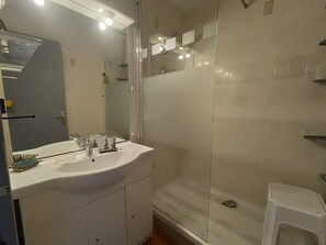 A bathroom with a white sink, mirror, and glass shower enclosure. - Duplex apartment with secure parking - 5 guests (Argelès-sur-Mer)