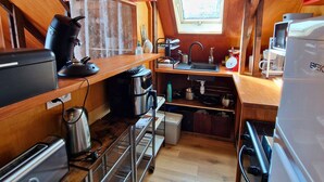 Una cocina compacta con fregadero, estufa y varios electrodomésticos.