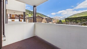 A balcony with a view of a mountain range and a building labeled 'La Marmotte.' - Cozy apartment at the slopes with WiFi and parking (Les Gets)