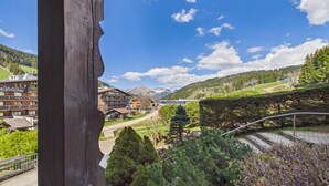 A mountain view with a wooden structure, a building with a sign, and a clear sky. - Cozy apartment at the slopes with WiFi and parking (Les Gets)