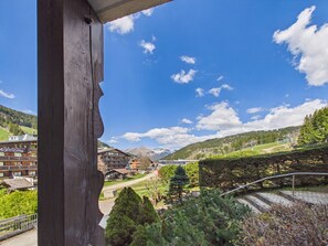Bergblick mit Holzbauten, ein Gebäude mit Schild und wolkenlosem Himmel.