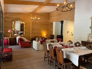 Un intérieur en bois comprenant un coin repas aménagé pour un repas, une cheminée et un grand miroir.