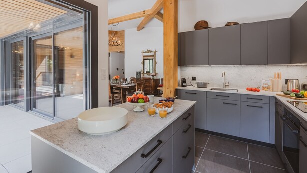 A modern kitchen with grey cabinets, a white countertop, and a large window. - Spacious penthouse with mountain view - 8 guests (Argentière)