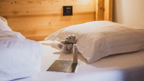 A neatly made bed with a plush toy and a brochure on it. - Spacious penthouse with mountain view - 8 guests (Argentière)