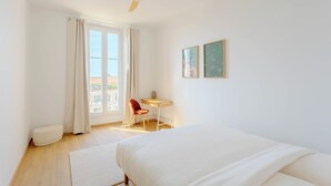A bedroom with a bed, a desk, a chair, and a ceiling fan. - Maison Mon Idée | Top floor, Bright, sea view and Palais des Festivals (Cannes)