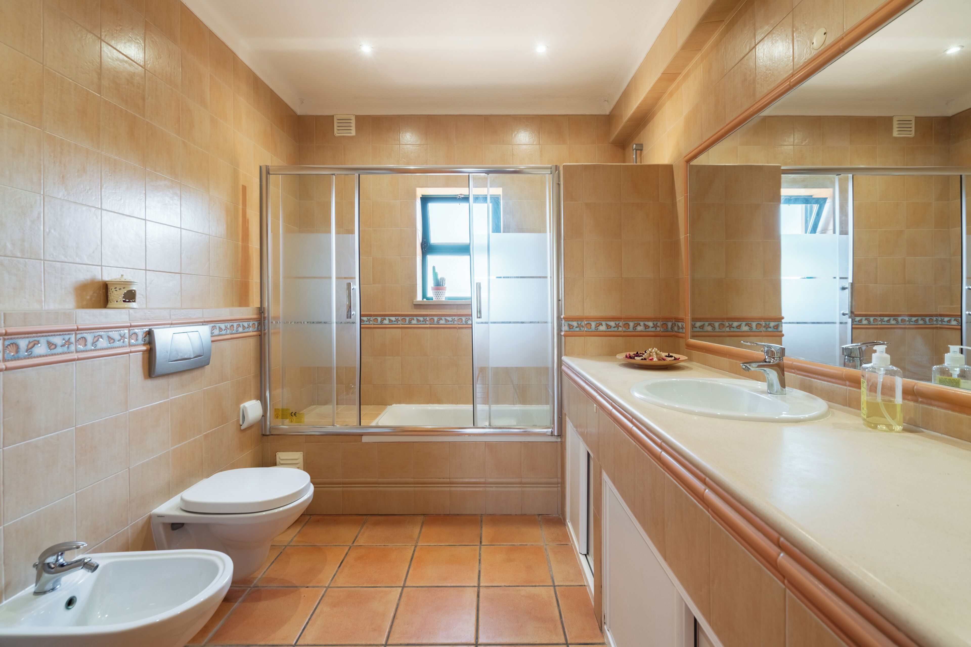 A bathroom with a toilet, sink, and shower.