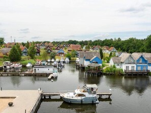 A marina with boats docked, surrounded by houses with red roofs. - 2 Person Holiday Park Home in Grosszerlang (Rheinsberg)