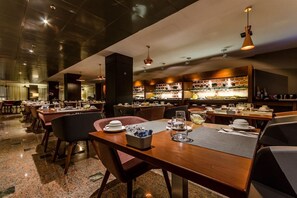 A restaurant with multiple tables, chairs, and a bar area. - Eurostars Andorra (Andorra la Vella)