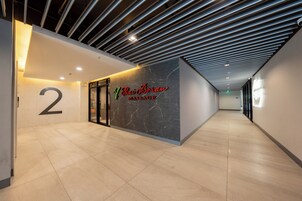 A hallway with a sign for Thai Boran Massage, a number '2' sign, and a modern ceiling design.