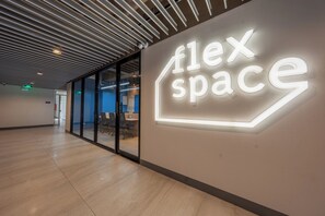 A modern interior with a 'flex space' sign, glass doors, and a wooden floor. - ABC Plus Hotel and Homes (Cebu City)