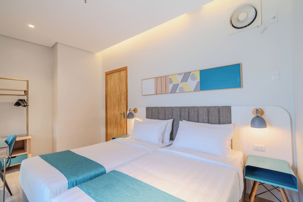 Une chambre avec deux lits, un bureau et une chaise.