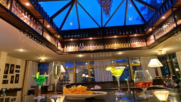 A bar with a high ceiling and a geometric glass structure. - Hotel De Leopol International (Addis Ababa)