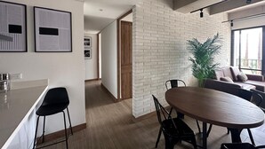 Et moderne køkken med spiseplads, en murstensvæg og en stor plante.