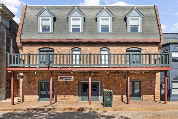 A two-story building with a balcony, brick facade, and signage for 'irisomnia cookies'. - The Accessible Atom on Historic Main (Saint Charles)