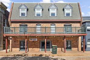 A two-story building with a balcony, brick facade, and signage for 'irisomnia cookies'. - The Accessible Atom | Historic Main (Saint Charles)