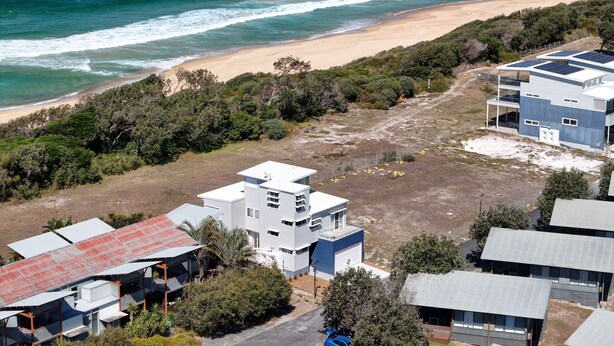 A coastal property with a beach view, a modern building with a flat roof, and a fenced area. - The Lookout – Resort Living with Panoramic Views Over Diamond Beach (Diamond Beach)