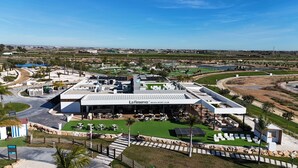 A modern building with a rooftop garden, outdoor seating, and a view of the surrounding landscape. - Designer Villa with Heated Pool on Santa Rosalia Lake Resort (Torre-Pacheco)