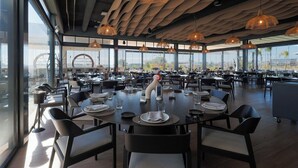 A spacious dining area with high ceilings, large windows, and modern pendant lighting. - Designer Villa with Heated Pool on Santa Rosalia Lake Resort (Torre-Pacheco)