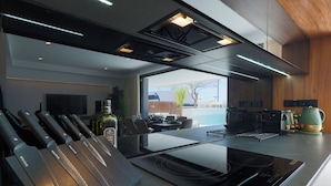 A modern kitchen with a built-in stove, a knife block, and a view to the outdoors. - Designer Villa with Heated Pool on Santa Rosalia Lake Resort (Torre-Pacheco)