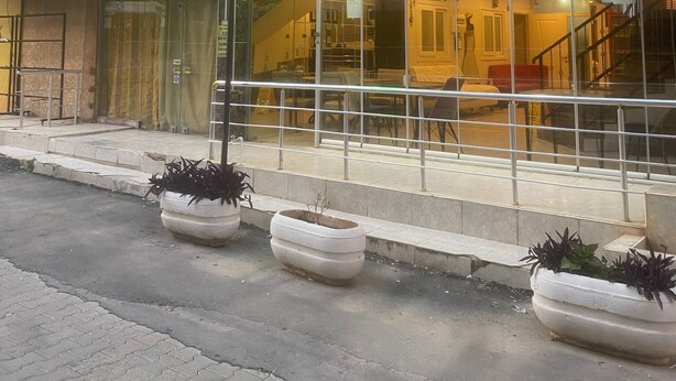 Ein Gebäude mit mehreren Schildern 'APART PANSIYON', einem grünen Schild für 'KARSU PANSIYON' und einer Treppe, die zu einer oberen Ebene führt.