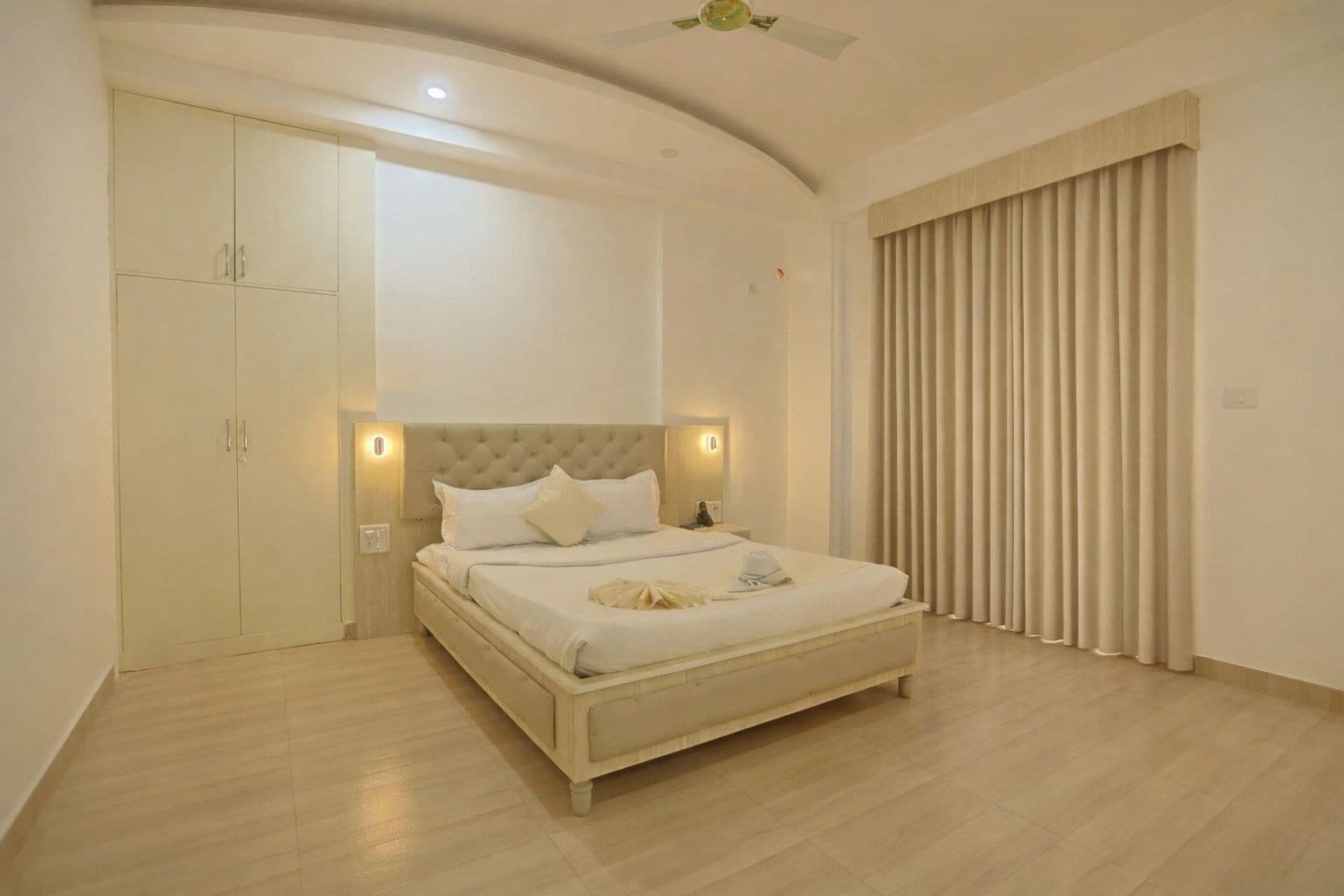 Une chambre à coucher avec un lit, une armoire et des rideaux.