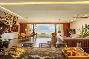 A spacious living area with a view of the sea, wooden furniture, and a modern design.