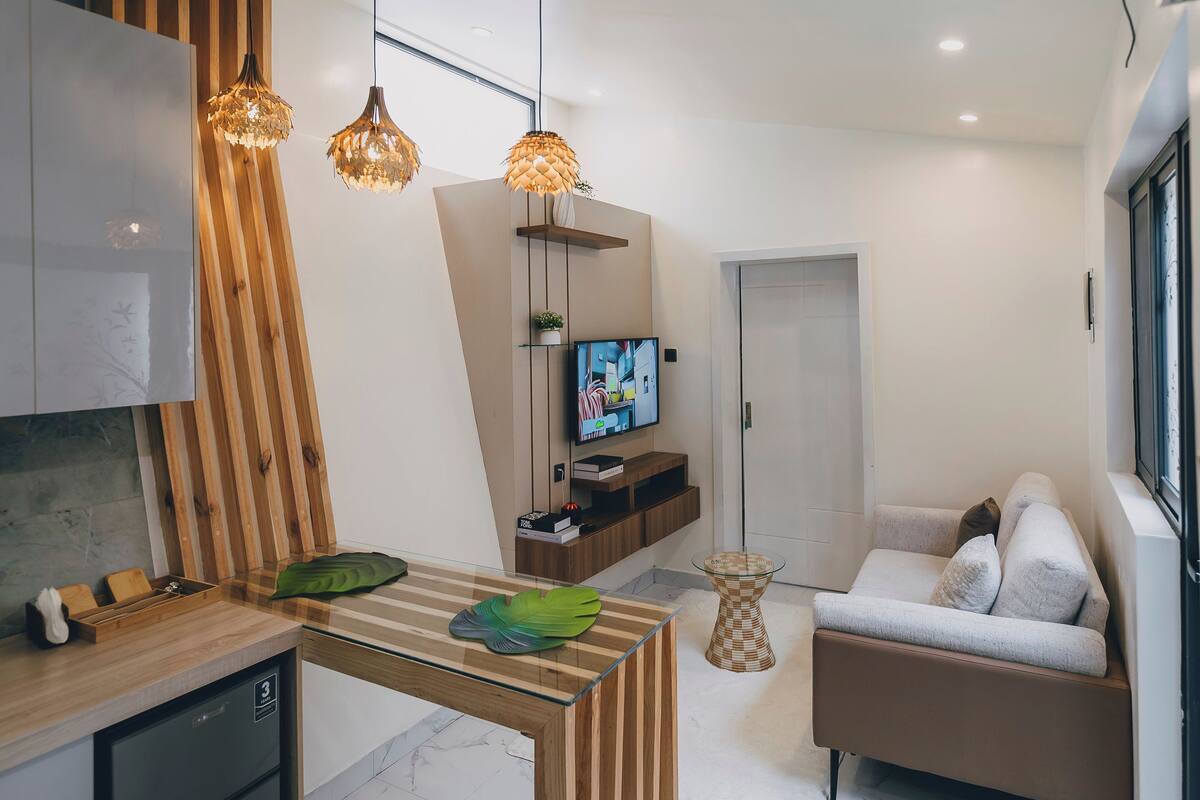 A modern kitchen with a wooden island, built-in appliances, and pendant lighting.