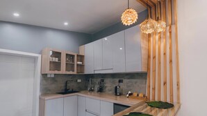 A modern kitchen with wooden cabinets, a marble backsplash, and a glass-top island. - Misteph Luxury Living (Kigali)