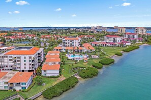 Luftaufnahme eines Küstenresorts mit mehreren Gebäuden, einem Schwimmbad und einer Marina.