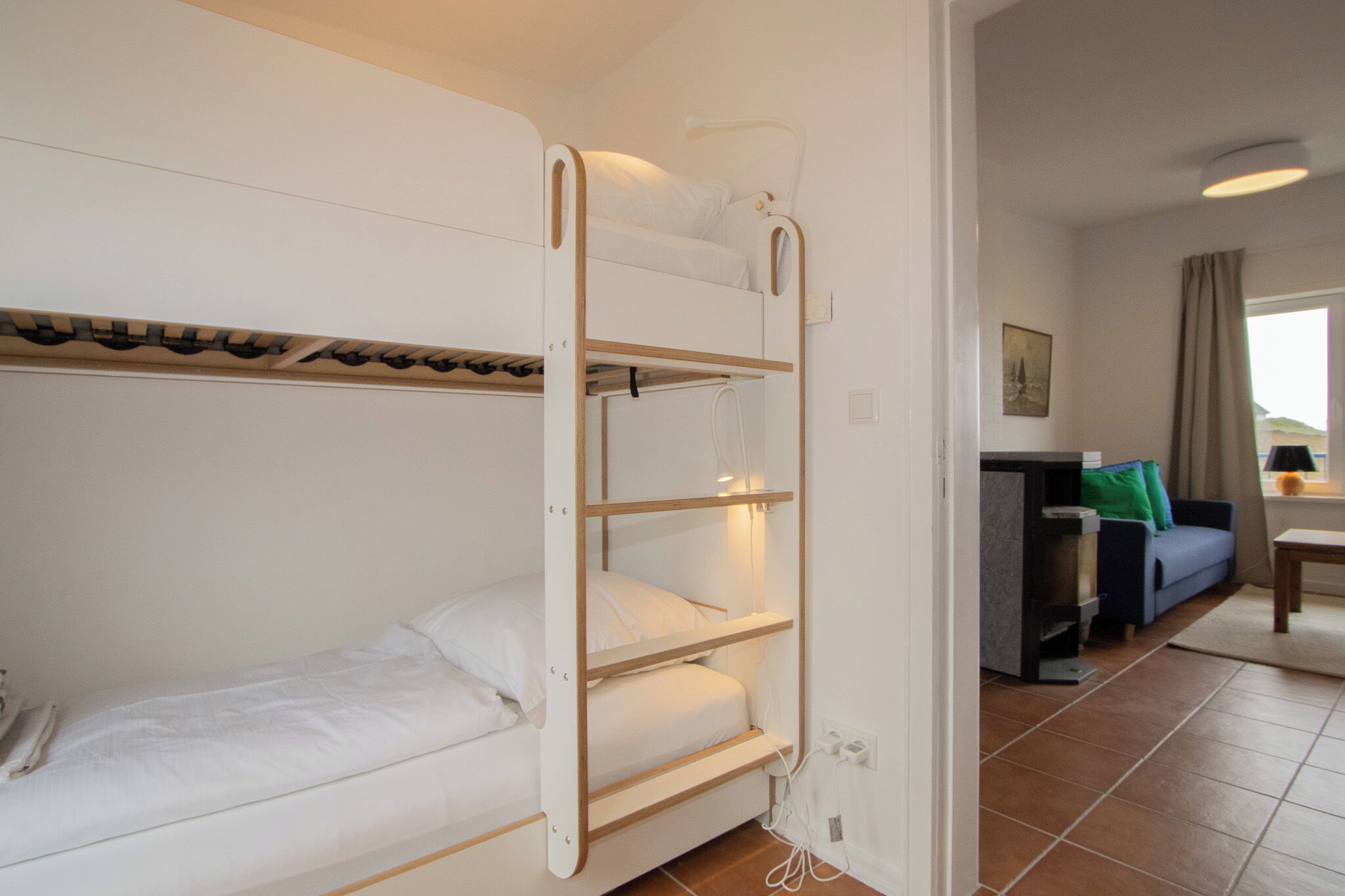 A bunk bed room with a desk and a sofa.