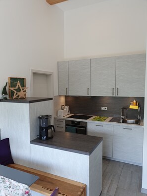 A modern kitchen with grey cabinets, a black coffee maker, a toaster, and a sink. - Modern living, quiet and close to nature in the Black Forest with its own garden area (Herrischried/Großherrischwand)