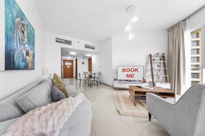 Ein modernes Wohnzimmer mit einer Couch, einem Couchtisch, einem Fernseher und einem Bild an der Wand.