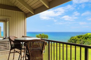 A balcony with wicker furniture overlooking a view of the ocean. - Pali Ke Kua #231 Serene Ocean Views, Walk to Beach (Princeville)