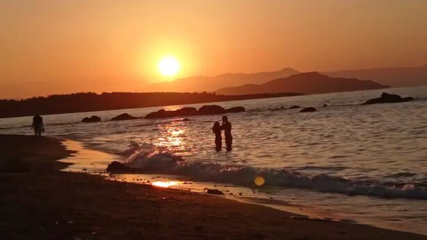 A sunset over a body of water with rocks and a distant mountain range. -  30m² studio 90m from the beach in Chania Self Check‑in Parking Garden Fast WiFi (Chania)