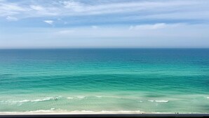 Een strand met helder turquoise water en uitzicht op de oceaan.