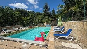 Una piscina con sillas de descanso y juguetes inflables.