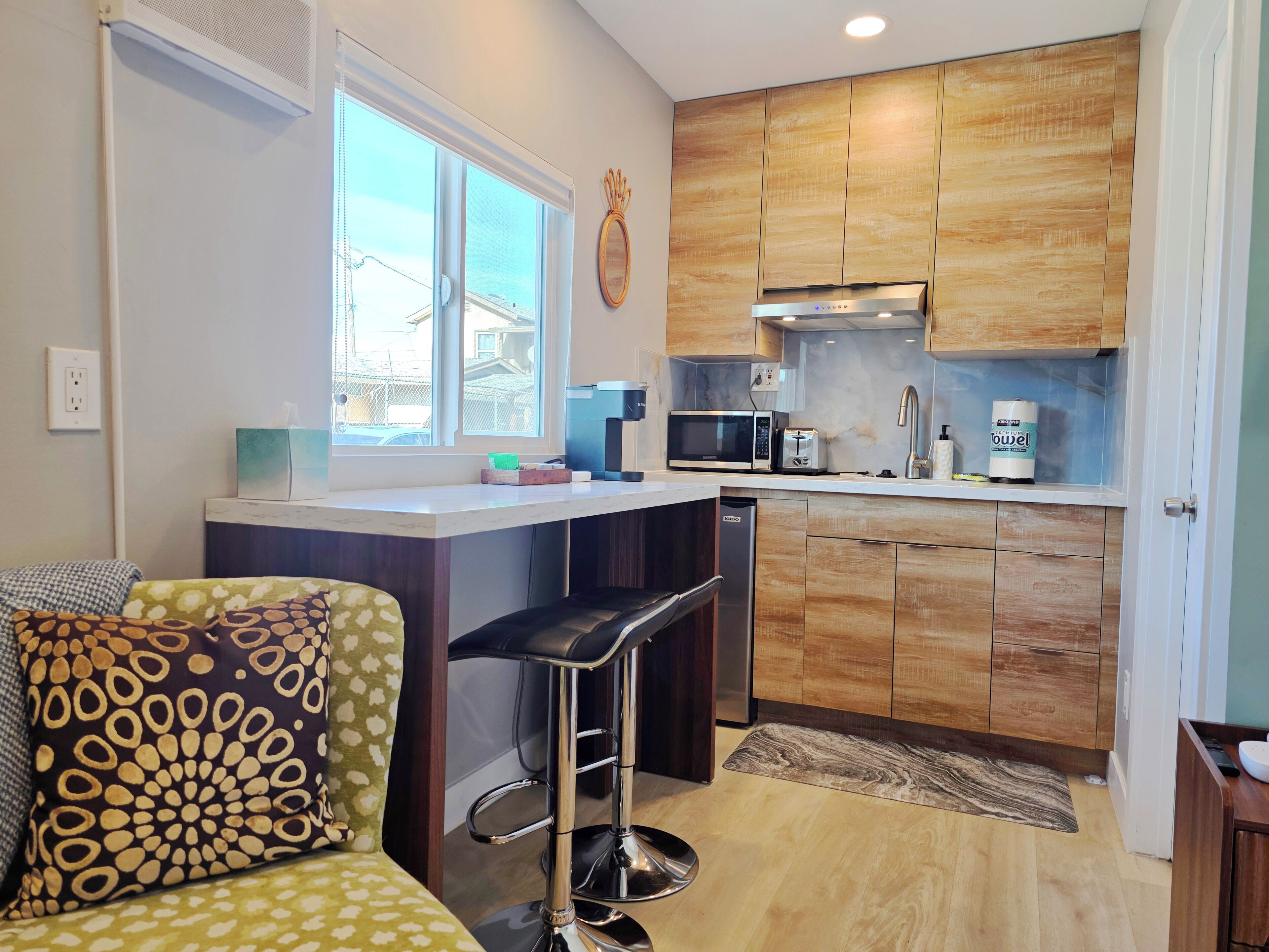 A modern kitchen with wooden cabinets, a microwave, a toaster, and a dishwasher.